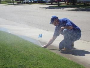 Flagging a pop up head during a sprinkler repair in Dallas, TX