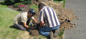 two of our University Park sprinkler repair specialists are fixing a bad sprinkler head